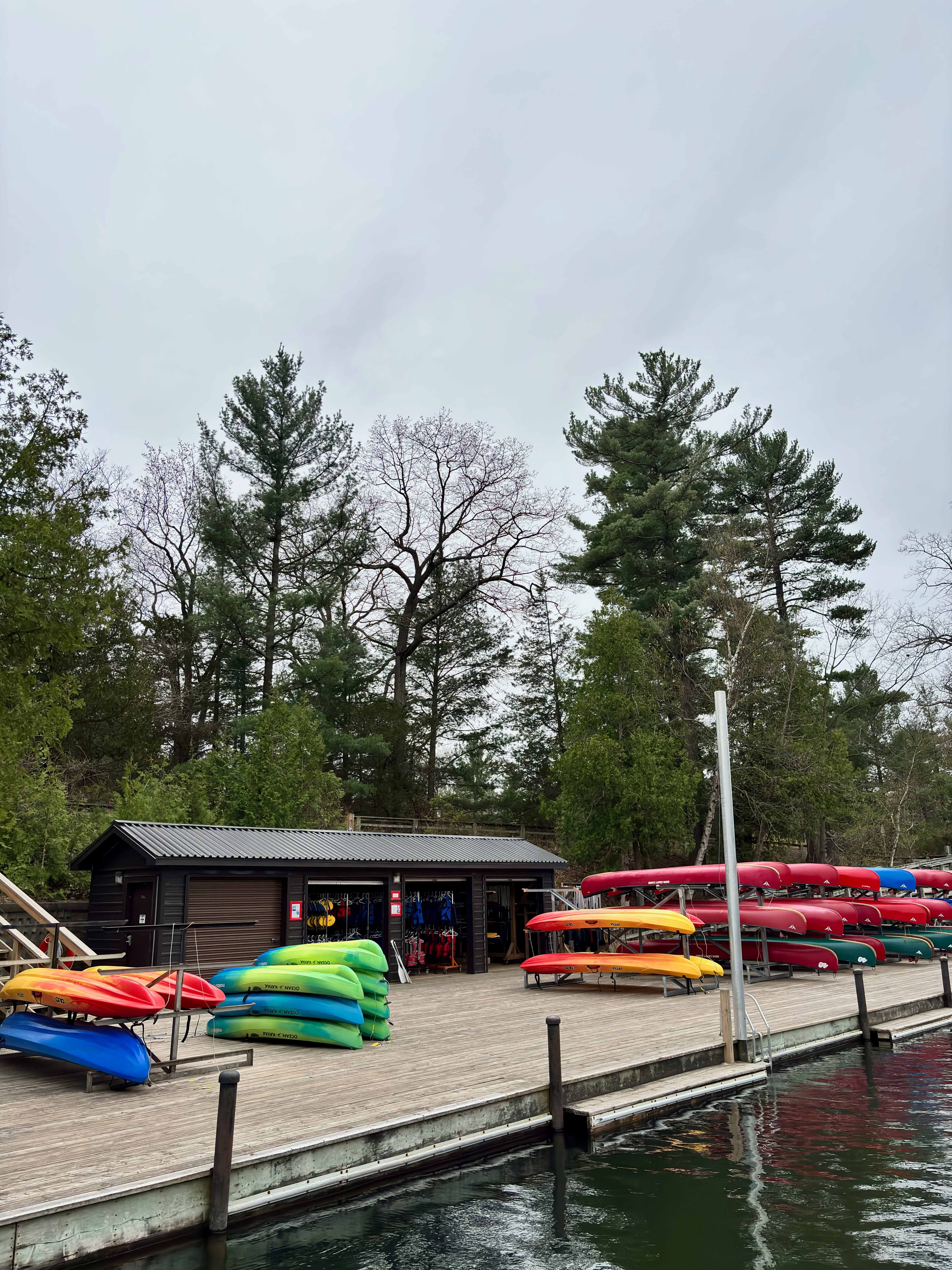 Lakeside boat rental facility with colorful kayaks and canoes