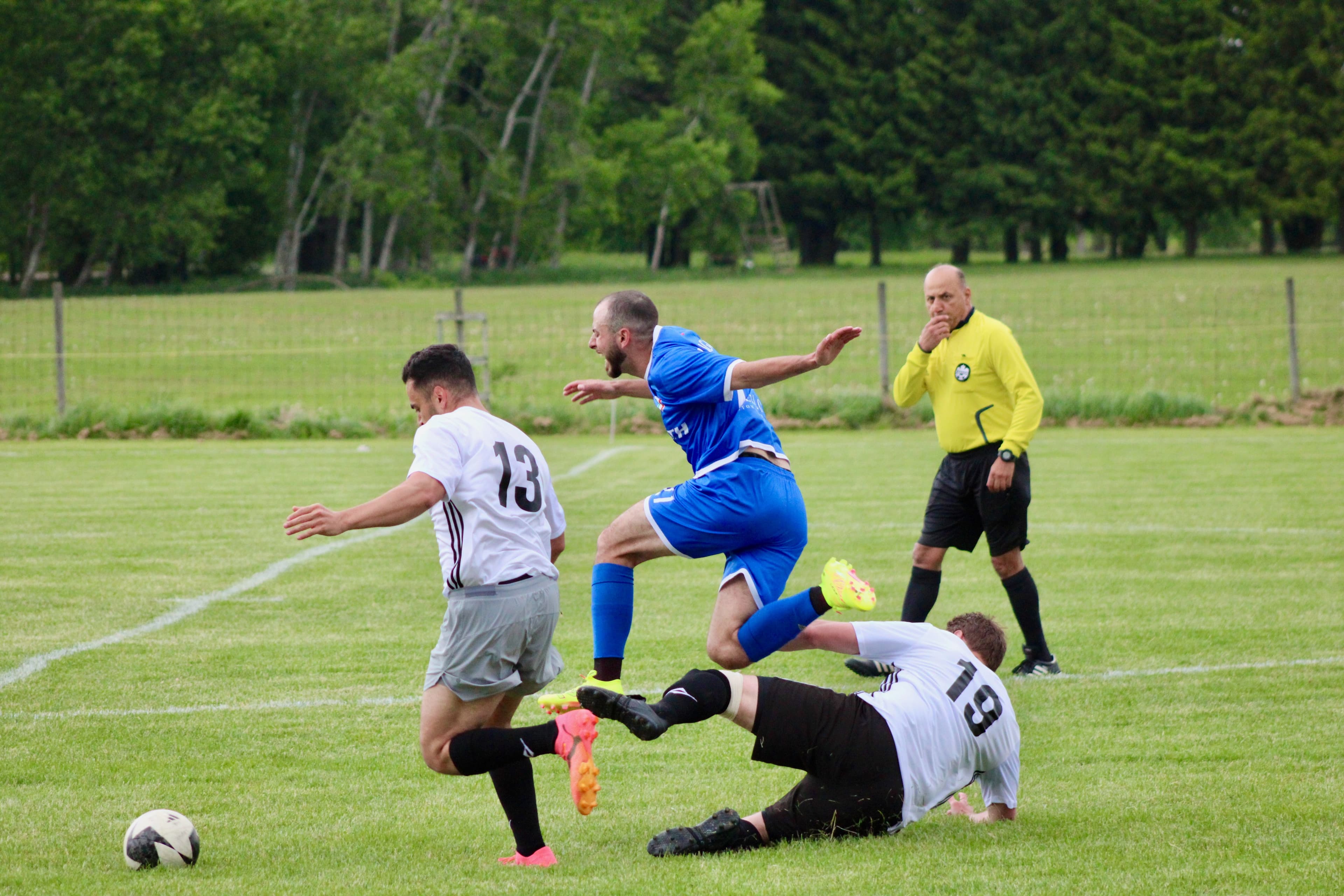 Soccer action with referee monitoring the play
